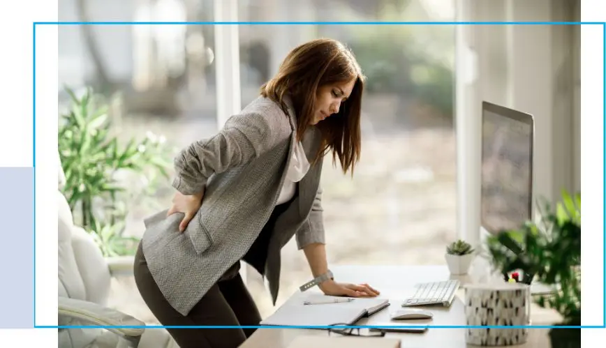 A woman standing at the desk with her back turned.