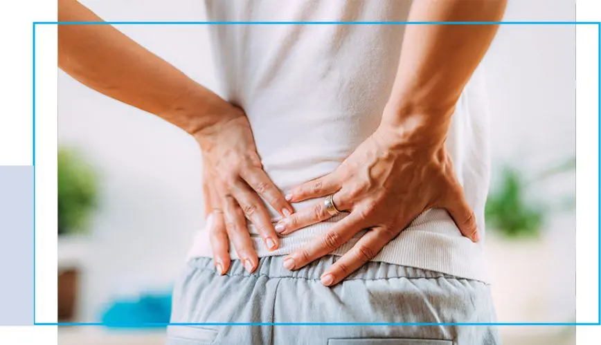 A person with their hands on the back of his lower body.