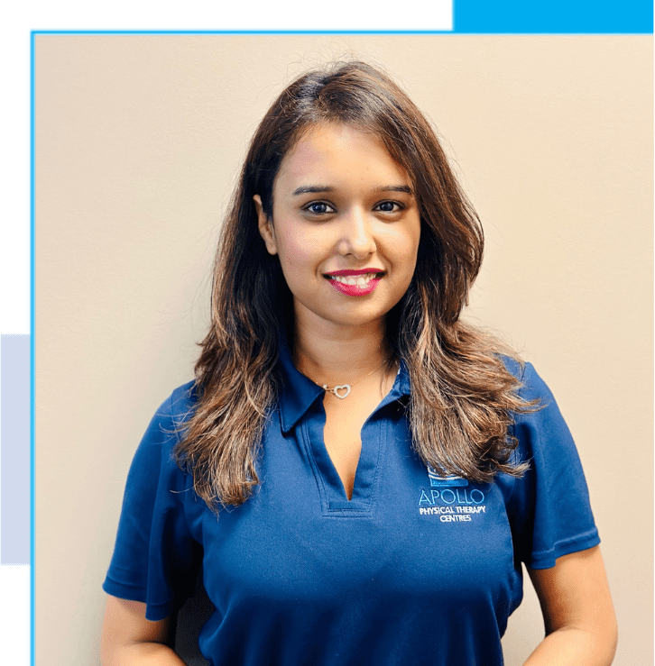 A woman in blue shirt standing next to wall.